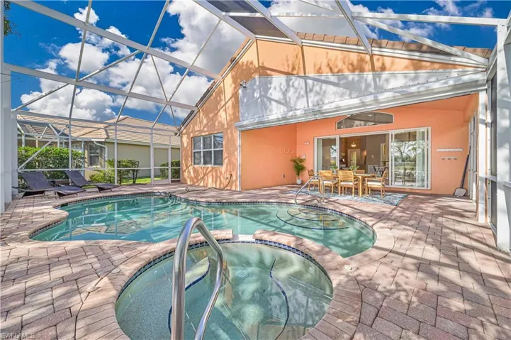 View of pool featuring an in ground hot tub, a patio, and glass enclosure