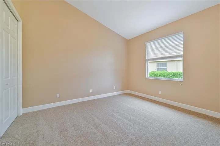Carpeted empty room with vaulted ceiling