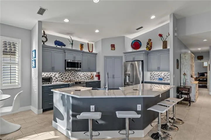 Tastefully updated kitchen with quartz counters, stainless GE Cafe appliances, soft close drawers, tile backsplash, and Advantium microwave.
