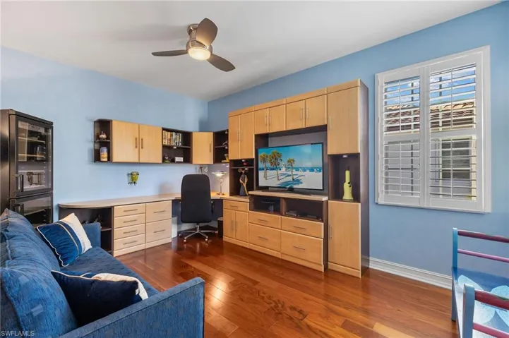 Guest bedroom with hardwood floors, walk in closet and Murphy bed that also serves as a sofa.