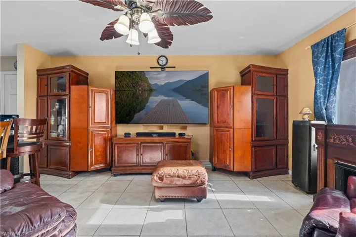 Living area featuring light tile patterned flooring and a ceiling fan