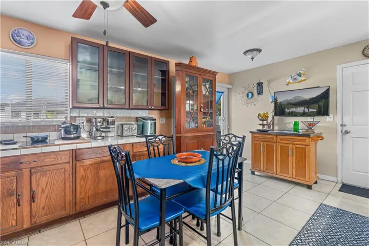 Dining space with light tile patterned flooring and ceiling fan