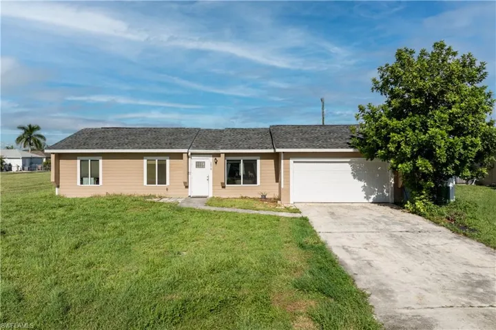 Ranch-style house with an attached garage, a front yard, driveway, and a shingled roof