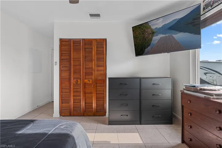Bedroom featuring light tile patterned floors, a closet, and a ceiling fan