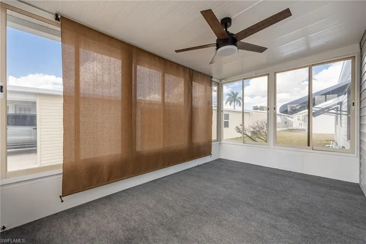 Unfurnished sunroom with ceiling fan