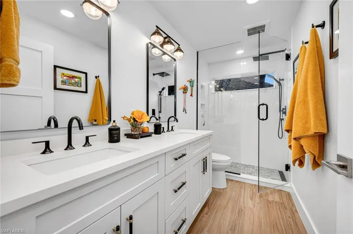 Guest bathroom is convenient to both guest bedrooms.  Dual sinks and seamless glass shower enclosure/door. Classic look that never goes out of style!
