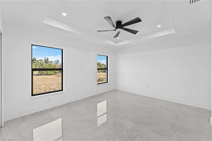 Unfurnished room with a raised ceiling and ceiling fan