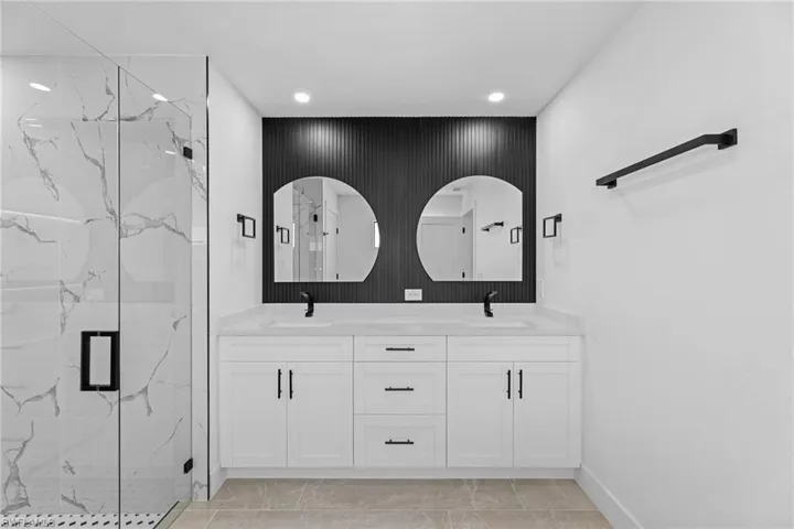 Bathroom with vanity and a shower with door