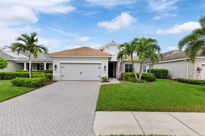 Mediterranean / spanish house featuring a garage and a front lawn