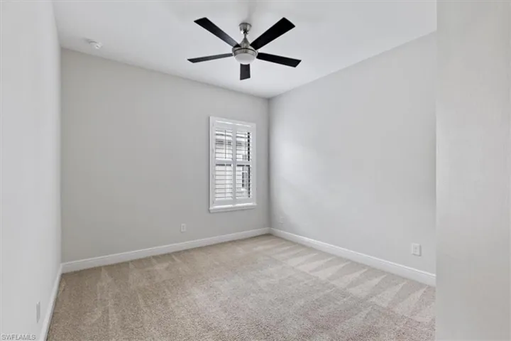 Empty room with carpet floors and ceiling fan