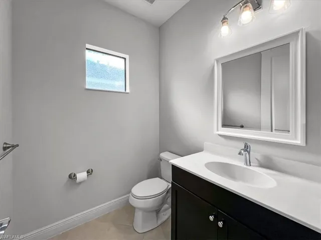 Bathroom featuring tile patterned flooring, vanity, and toilet