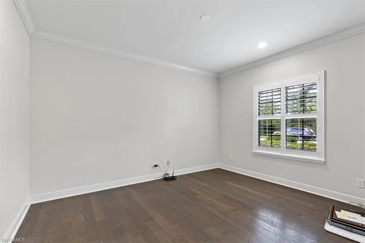 Unfurnished room with dark hardwood / wood-style floors and crown molding