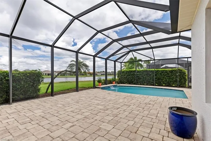 View of swimming pool featuring a water view, a lanai, and a patio area