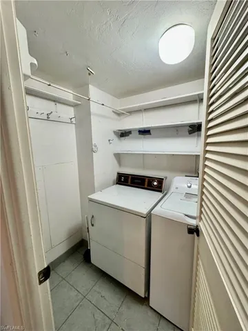 Washroom featuring a textured ceiling and separate washer and dryer