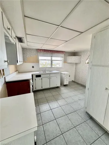 Kitchen featuring white cabinetry, sink, and light tile patterned floors