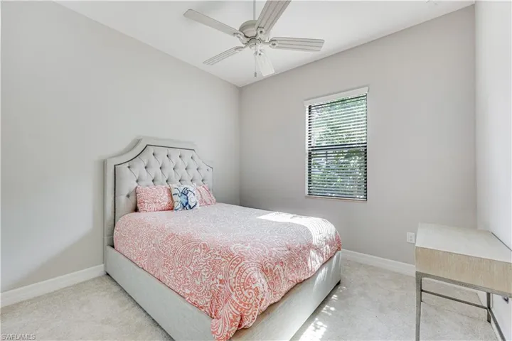 Carpeted room featuring a window with blinds, a ceiling fan, and light-toned walls