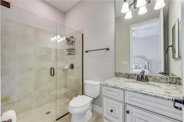 Shower with clear glass enclosure and light-toned tile surround