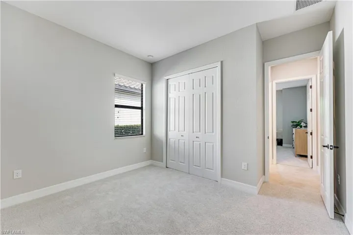 Carpeted room with a double bi-fold closet, single window with blinds, and light-toned wall paint