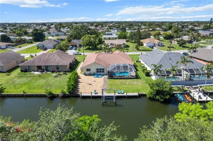 Aerial perspective of suburban area featuring a nearby body of water