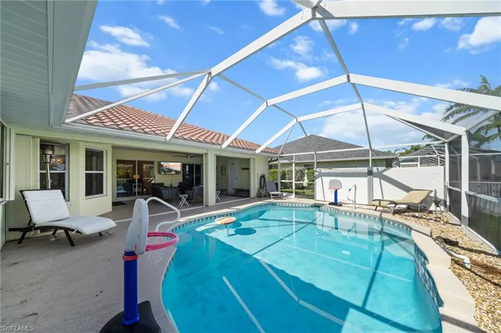 Swimming pool featuring a sunroom, a patio, a lanai, and a ceiling fan