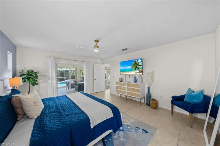 Tiled bedroom with access to exterior and ceiling fan