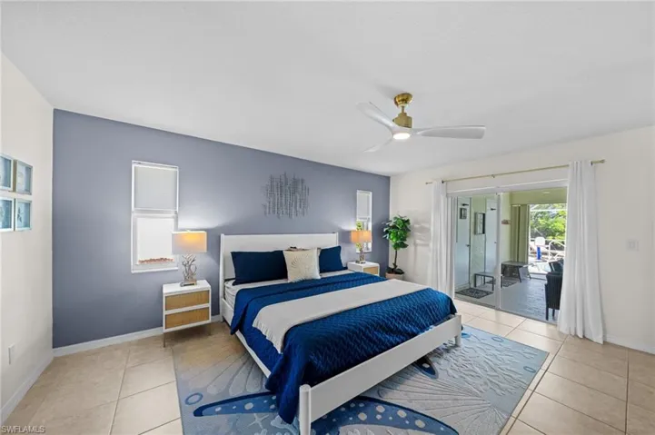 Bedroom with light tile patterned floors, a ceiling fan, and access to outside