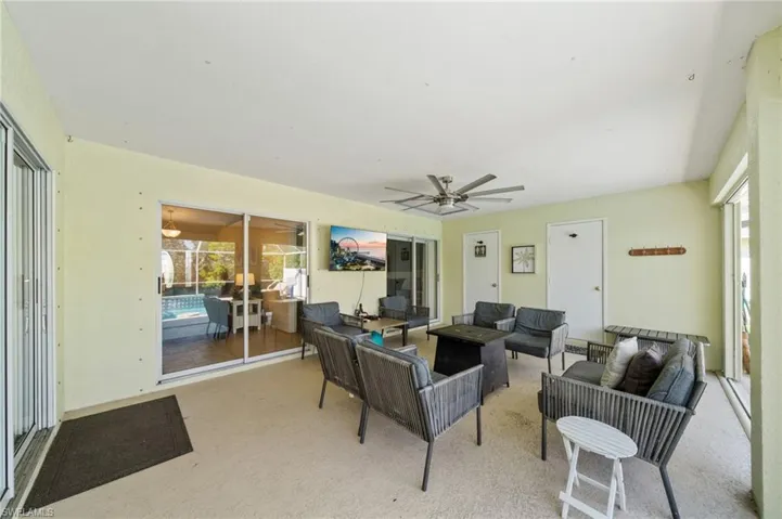 Carpeted living area with plenty of natural light and a ceiling fan