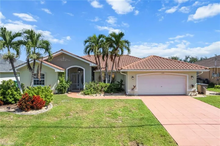 View of front of home featuring a garage, concrete driveway, stucco siding, and a front yard