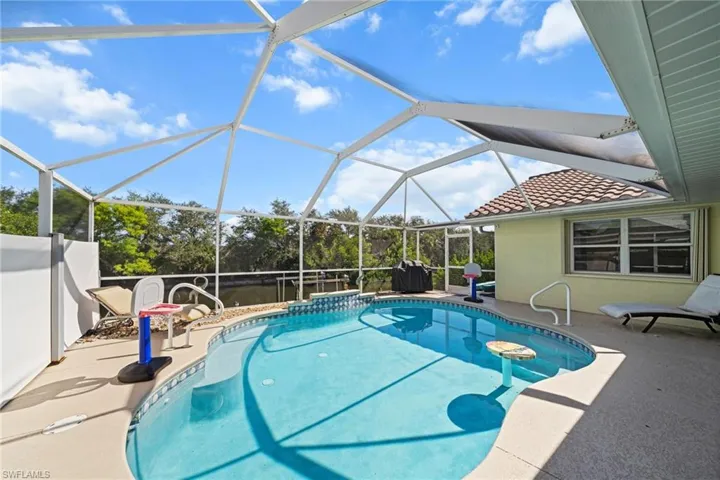 Outdoor pool featuring a patio area, a sunroom, and glass enclosure