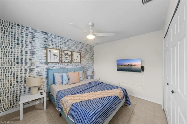 Bedroom featuring light tile patterned floors, a closet, and ceiling fan