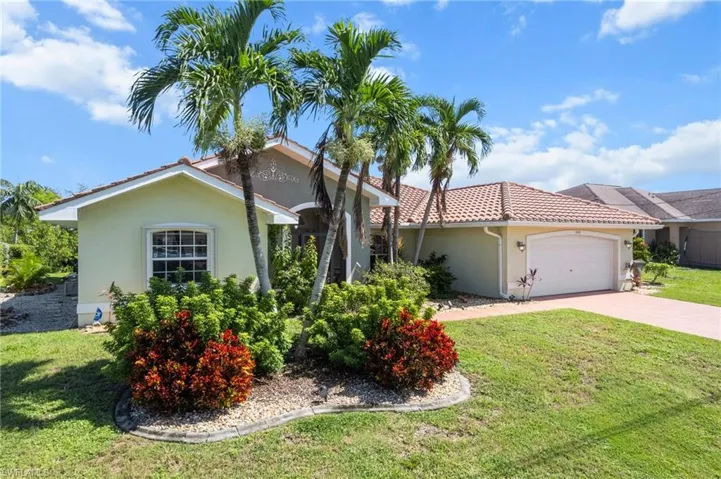 View of front of house with an attached garage, stucco siding, concrete driveway, and a front lawn