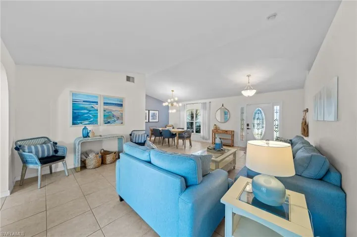 Tiled living room with vaulted ceiling and a chandelier