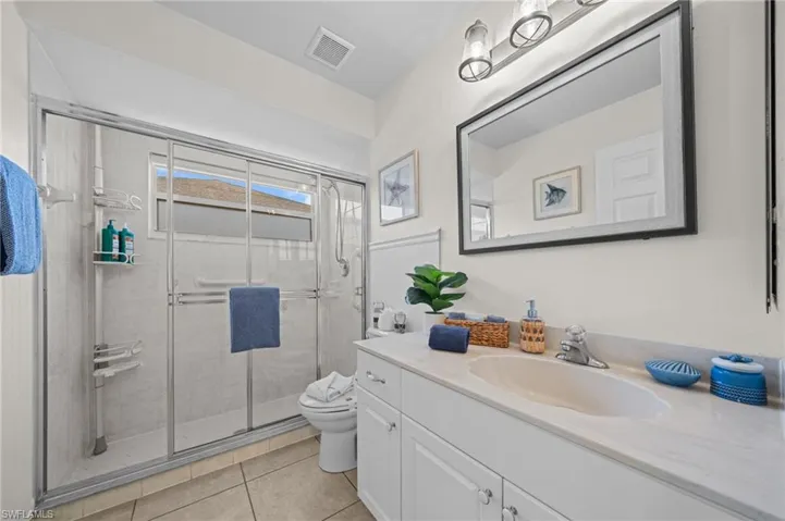 Bathroom featuring vanity, a stall shower, and light tile patterned floors