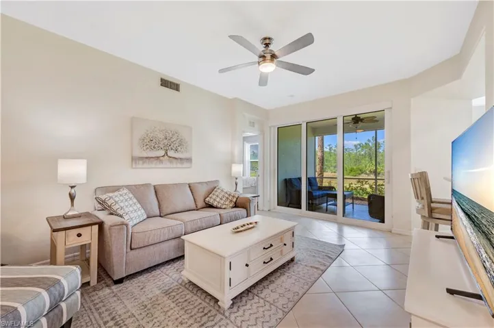 Living room with light tile patterned floors and ceiling fan