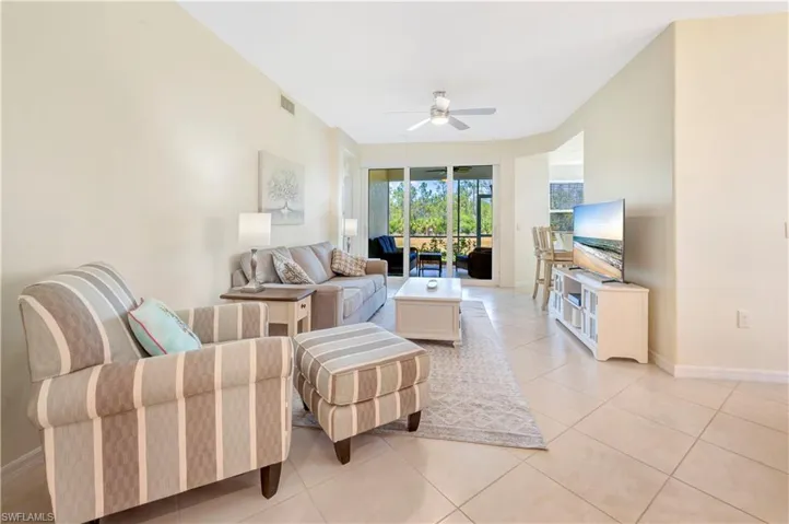 Living room with light tile patterned flooring and ceiling fan