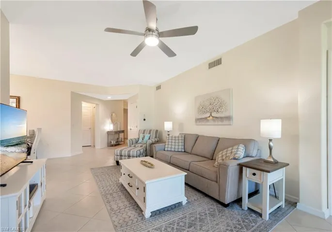 Living room featuring light tile patterned flooring and ceiling fan