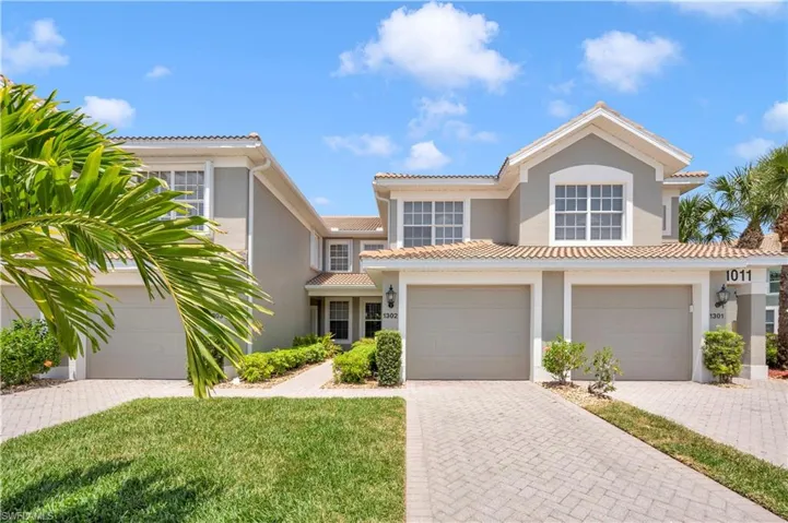 Mediterranean / spanish-style house with stucco siding, decorative driveway, a tile roof, and a front yard