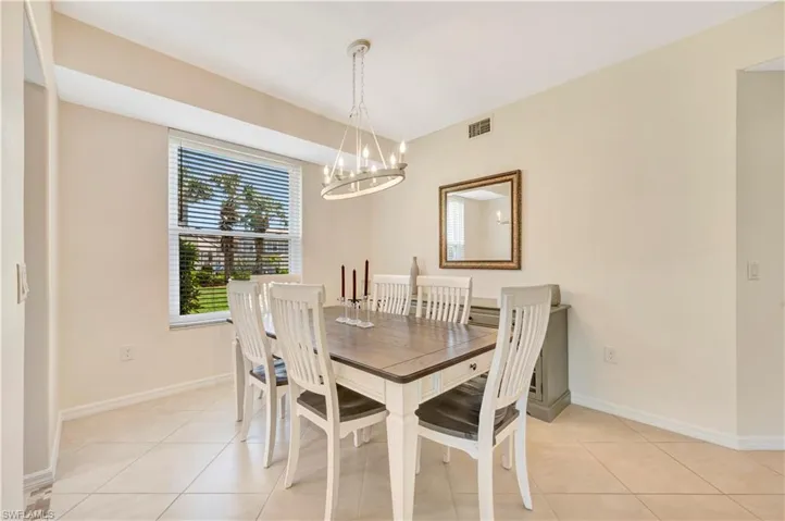 Dining space with light tile patterned floors and a chandelier