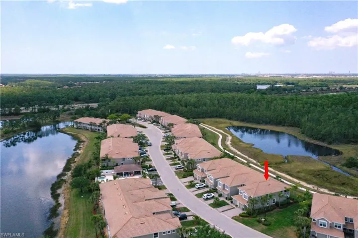 Aerial view of property's location featuring a nearby body of water and nearby suburban area