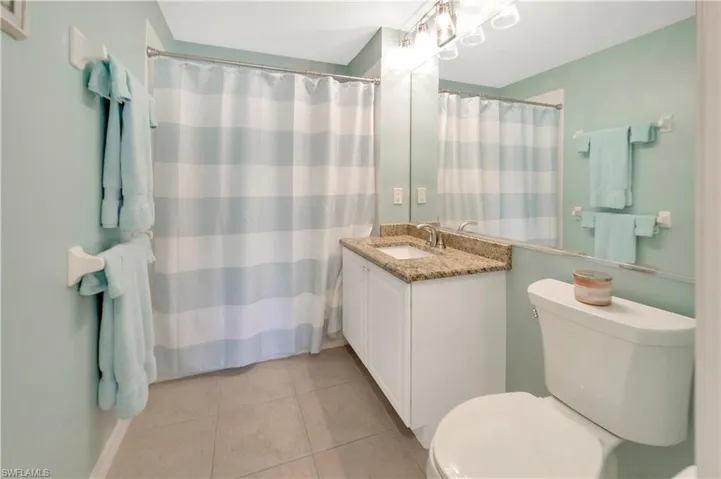 Guest Bathroom with vanity, a shower with shower curtain, and light tile patterned flooring