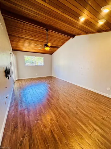 Spare room with light wood-style floors, wood ceiling, and a ceiling fan