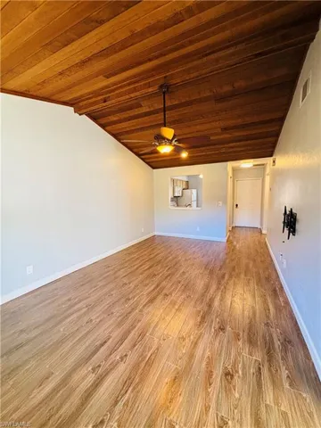 Unfurnished living room featuring light wood-type flooring, wood ceiling, and ceiling fan