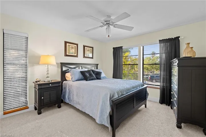 Bedroom featuring baseboards, ceiling fan, and light colored carpet