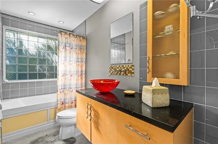 Bathroom with a shower,  with shower curtain, bathing tub, and toilet