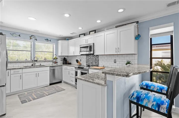 Kitchen featuring a sink, ornamental molding, visible vents, and stainless steel appliances