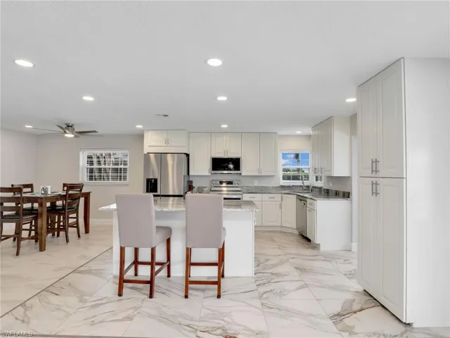 Kitchen featuring a water view, recessed lighting, and marble finish floors
