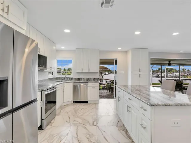 Kitchen featuring a water view, recessed lighting, and marble finish floors