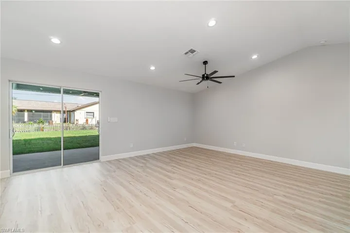 Empty room with lofted ceiling, light hardwood / wood-style flooring, and ceiling fan