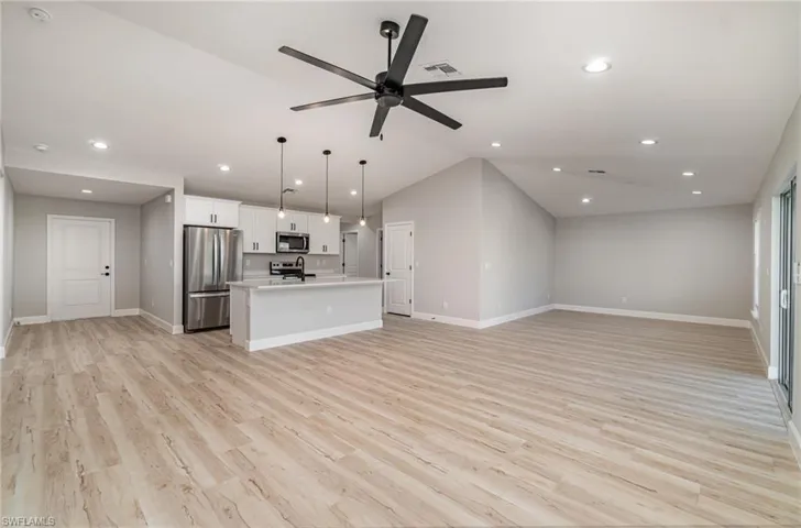 Kitchen featuring light hardwood / wood-style flooring, stainless steel appliances, and a center island with sink