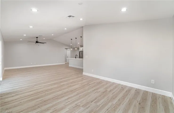 Unfurnished living room featuring light hardwood / wood-style flooring, lofted ceiling, and ceiling fan